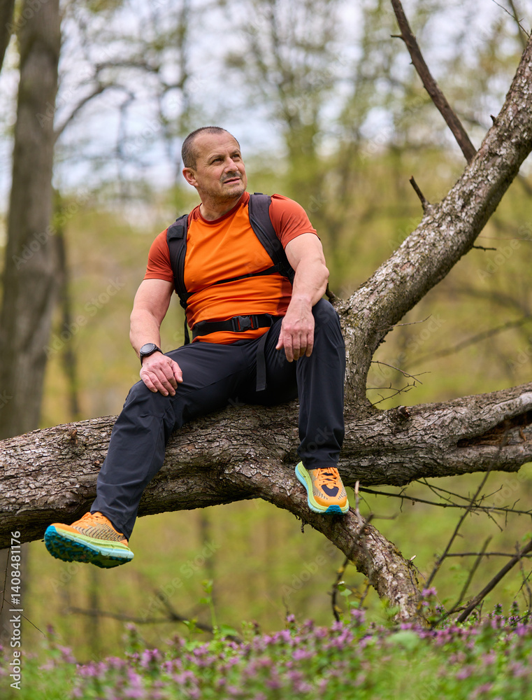 Man sitting on fallen tree resting
