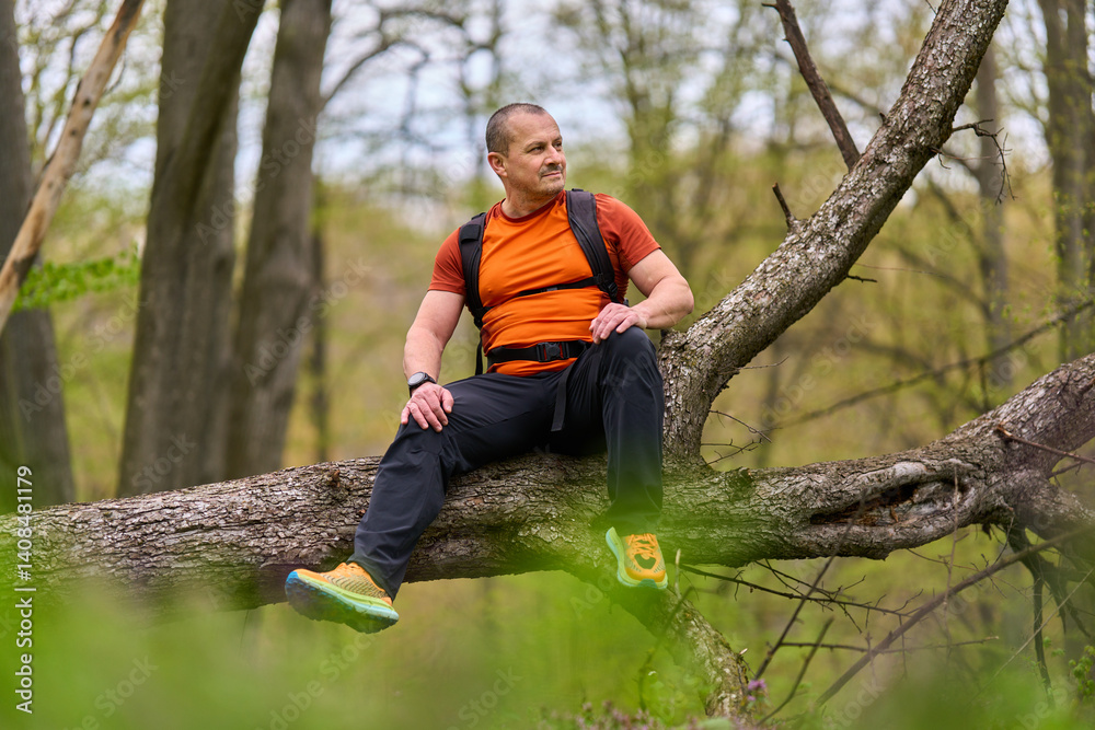 Man sitting on fallen tree resting