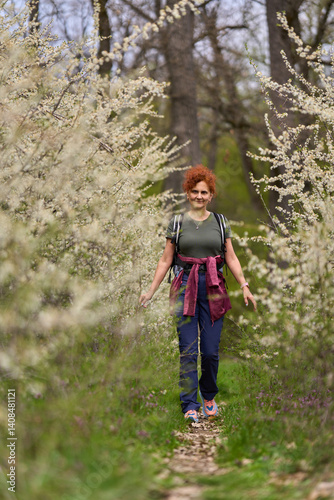 Woman walking through blooming blackthorn