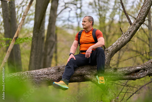 Obraz na płótnie Man sitting on fallen tree resting w salonie