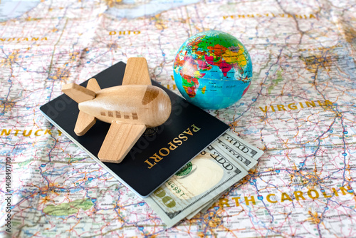 Planning a trip to the United States. Passport, cachet and model airplane with globe on a map of America.
