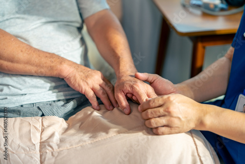 Asian senior man patient doing rehab physical therapy stretching muscle hand and fingers with physiotherapist caregiver in bedroom. Home medical caregiving services and elderly people healthcare.