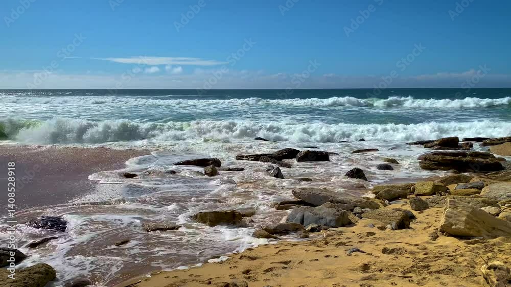 Powerful turquoise waves crash against a rocky shore under a vibrant blue sky. Natural beach scenery. Perfect tranquil coastal background for vacation themes, wellness, and nature-inspired design. Powerful turquoise waves crash against a rocky shore under a vibrant blue sky. Natural beach scenery. Perfect tranquil coastal background for vacation themes, wellness, and nature-inspired design.