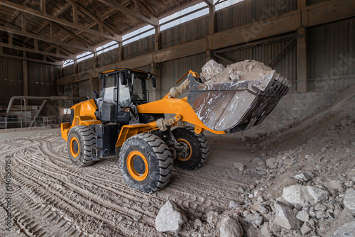 Bulldozer work with raw stuff at gypsum factory