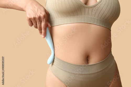 Obraz na płótnie Beautiful young woman in sexy underwear with vibrator on beige background, closeup w salonie