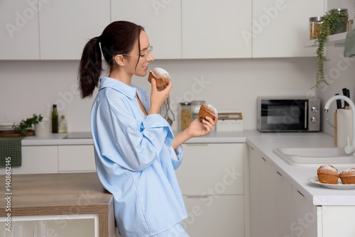 Young woman eating tasty mu...