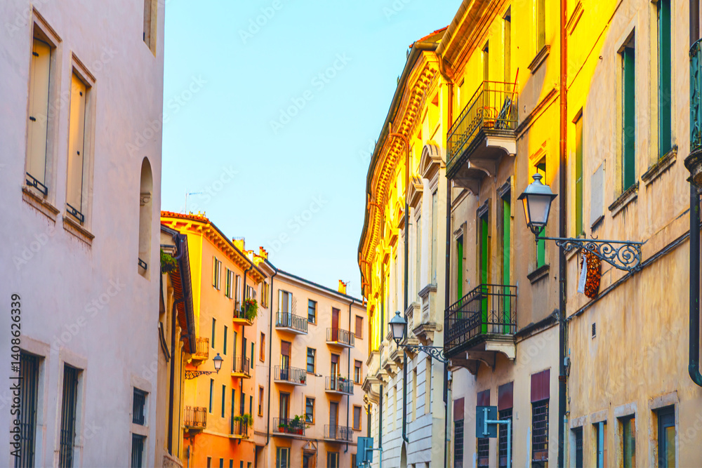 Warm sunlight bathes a charming Italian street lined with colorful historic buildings and balconies. A peaceful, vibrant atmosphere perfect for travel, architecture, or lifestyle themes