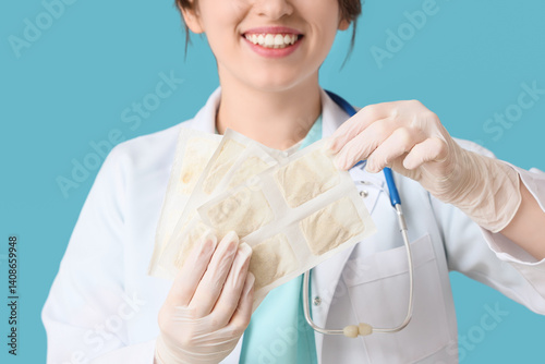 Female doctor with mustard plasters on blue background, closeup