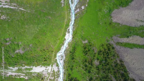 This aerial footage showcases the breathtaking Zillertal Valley in Tyrol, Austria, with a winding river flowing through lush meadows surrounded by dramatic mountains.