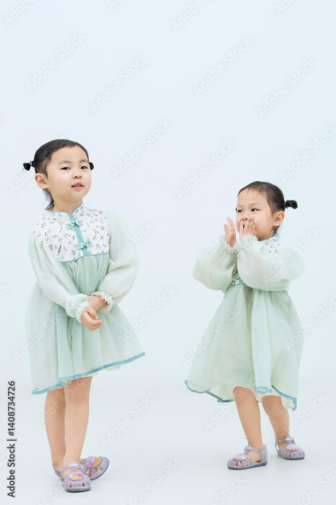 Playful cute twin little girls on white background Playful cute twin little girls on white background
