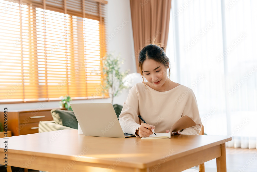 Young Asian woman happy positive cute beautiful business woman sit indoors in living room using laptop computer Young Asian woman happy positive cute beautiful business woman sit indoors in living room using laptop computer