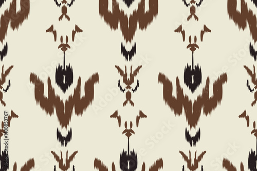 Seamless ikat pattern with traditional brown and black tribal motifs on a cream background. Perfect for ethnic fabric designs, textile prints, wallpapers and bohemian decor themes.