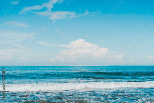 Fototapeta Naklejka Na Ścianę i Meble -  Open sea with calm waves and tropical blue sky, great for peaceful summer vacation themes.
