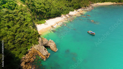 Aerial view of a beautiful tropical beach with turquoise water, white sand, lush vegetation, and a boat sailing peacefully near the shore, creating a serene and idyllic scene