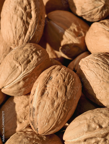 Natural background of walnuts lying under the bright sun,close-up