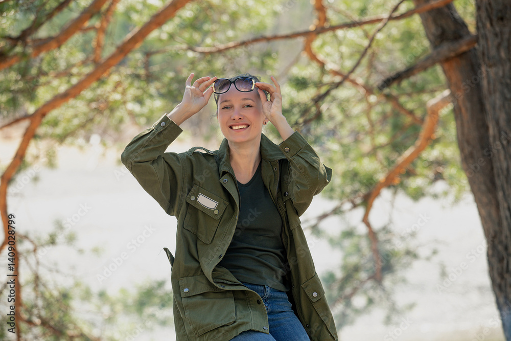 A female tourist in nature in the forest is relaxing at a campsite, happy A female tourist in nature in the forest is relaxing at a campsite, happy