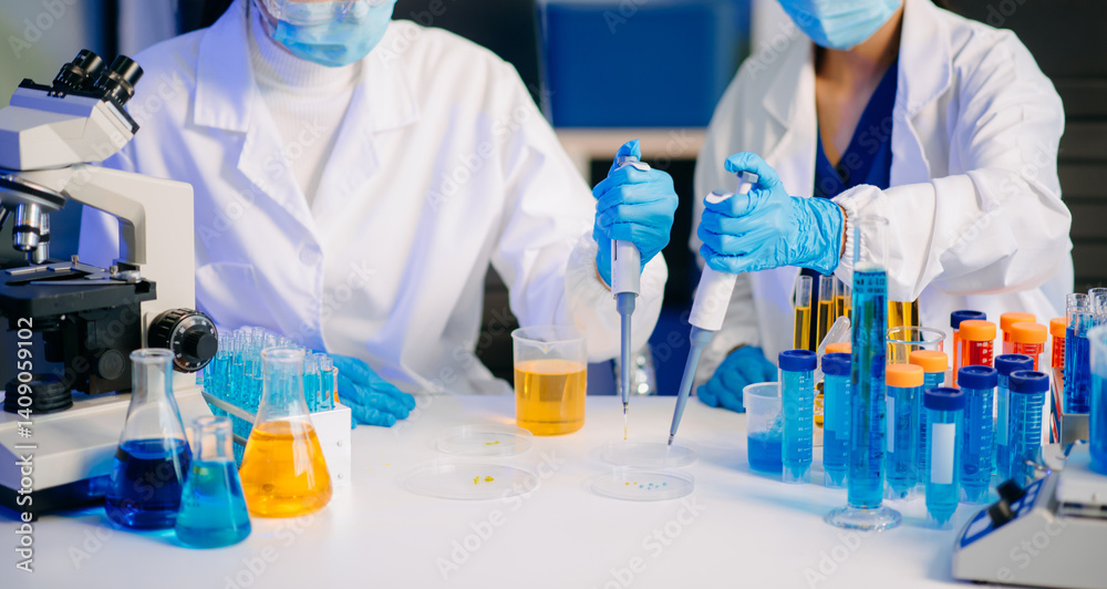 Two female biotechnologists testing new chemical substances in a laboratory.