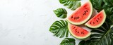 Palm leaves adorn a vibrant watermelon slice that has been placed on a plain white background