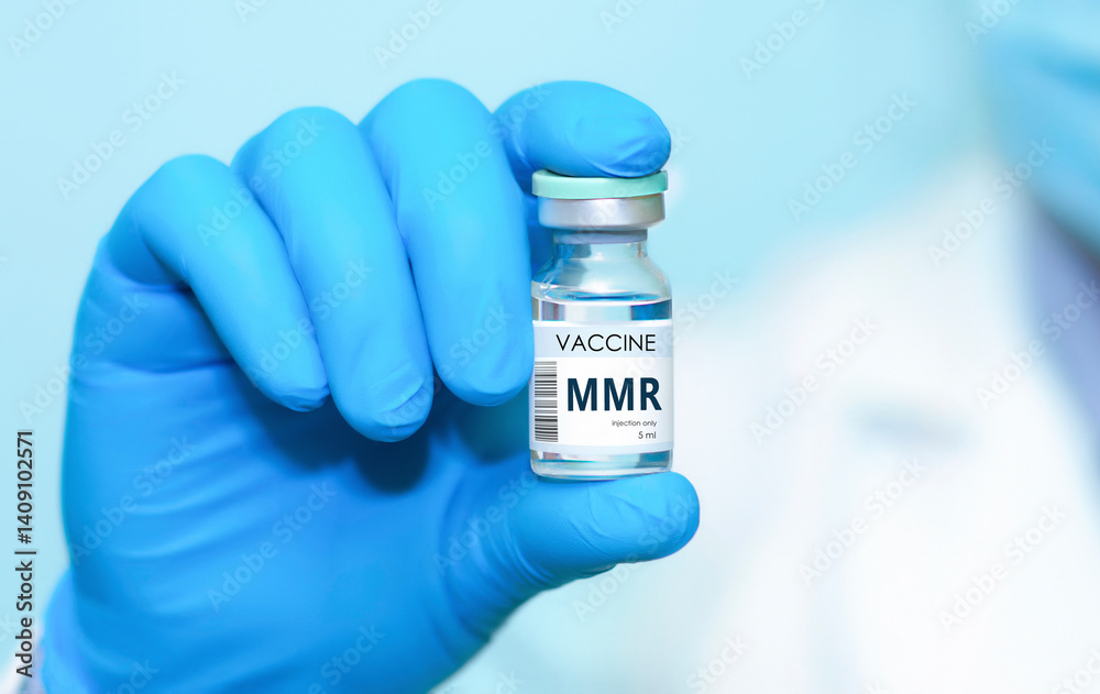 Doctor wearing protective gloves holding a bottle of MMR vaccine for measles, mumps, and rubella, used for immunizing children and adolescents. Concept of medicine, healthcare, vaccination awareness
