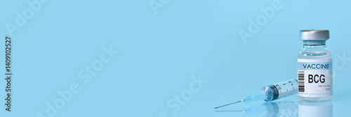 BCG (tuberculosis vaccine bottle with syringe on blue background. Concept of global immunization, scientific medical research, disease prevention, modern healthcare awareness and copy space for design photo