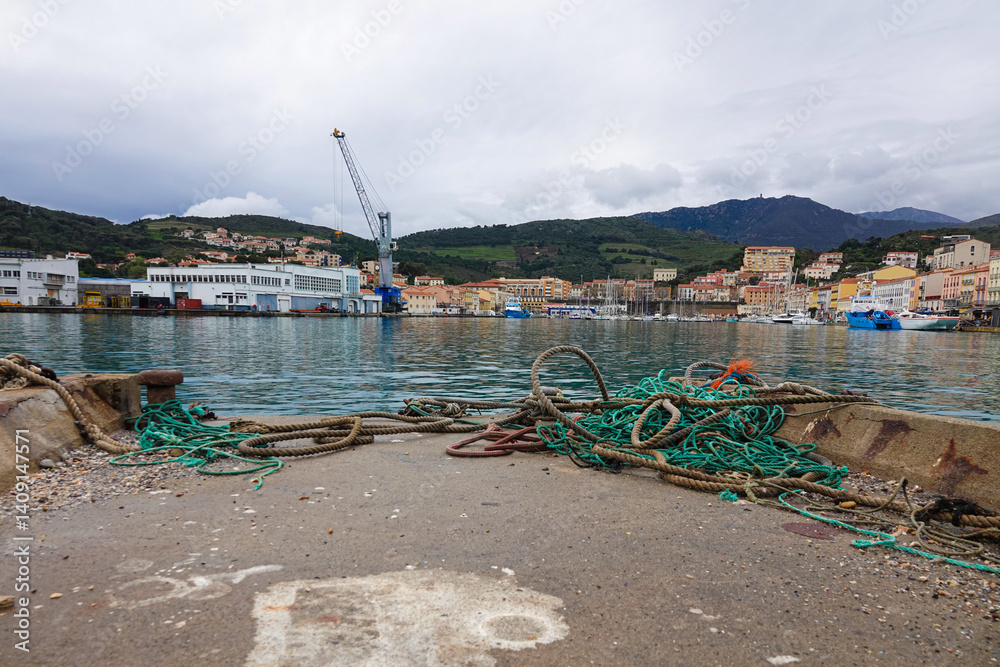 A tranquil harbor features small boats moored alongside a waterfront.