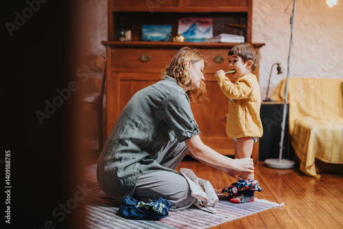 Cuadro en lienzo A caring mother assists her toddler to get dressed in a cozy and family-oriented house, emphasizing bonding
