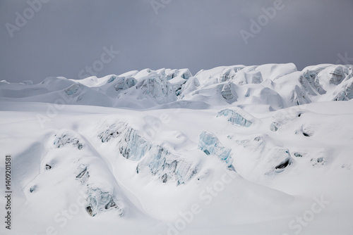 Crevassed glacier ice covered in fresh snow photo