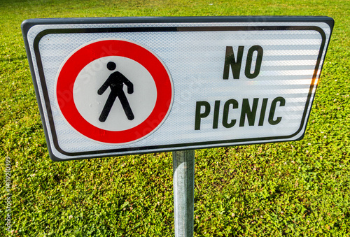 Obraz na płótnie Sign forbidding picnics in a green park indicating restriction for pedestrians enjoying outdoor activities during a sunny day w salonie