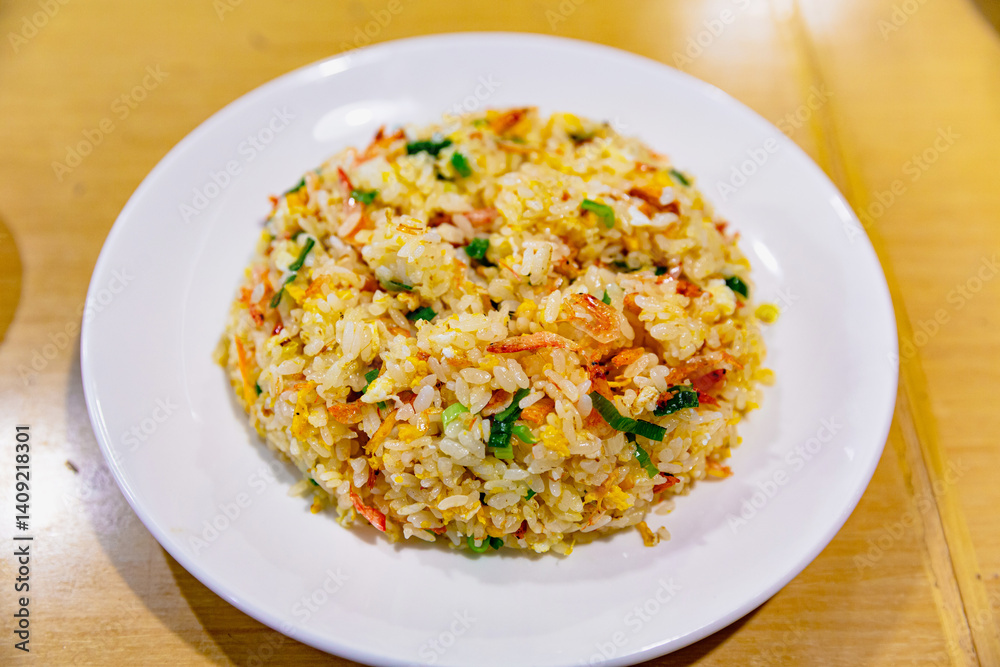 Taiwanese-style egg fried rice with sakura shrimp served in a white plate, golden grains glistening with oil and umami flavor Taiwanese-style egg fried rice with sakura shrimp served in a white plate, golden grains glistening with oil and umami flavor