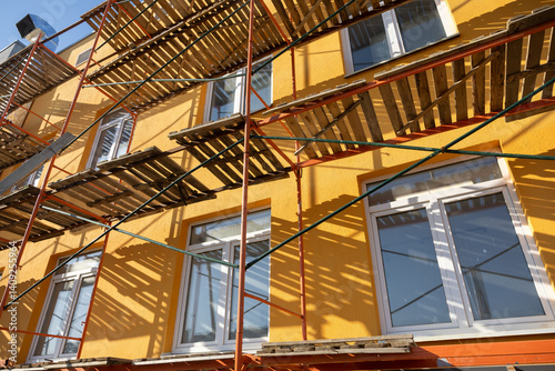 Building facade renovation, scaffolding. Extensive scaffolding providing platforms for work during renovation in a multi-story building