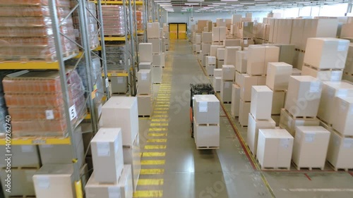 A vast warehouse, filled with rows of white boxes and crates, features a forklift navigating the aisles, highlighting the efficient storage and movement of goods.