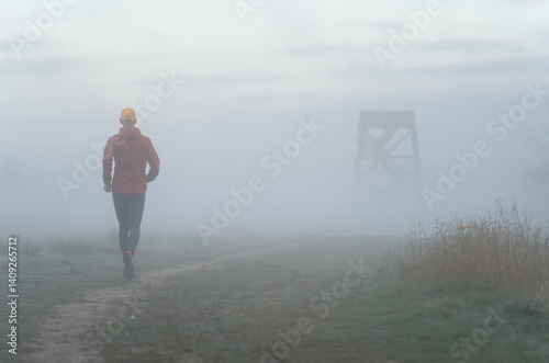 Obraz na płótnie Man running in the foggy, Dutch countryside on a cold morning. w salonie