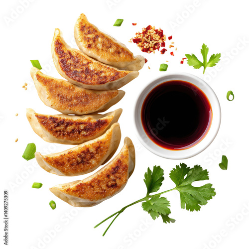 Overhead shot of fried dumplings with soy sauce, chili flakes, and green onions on a white background. Asian cuisine concept.