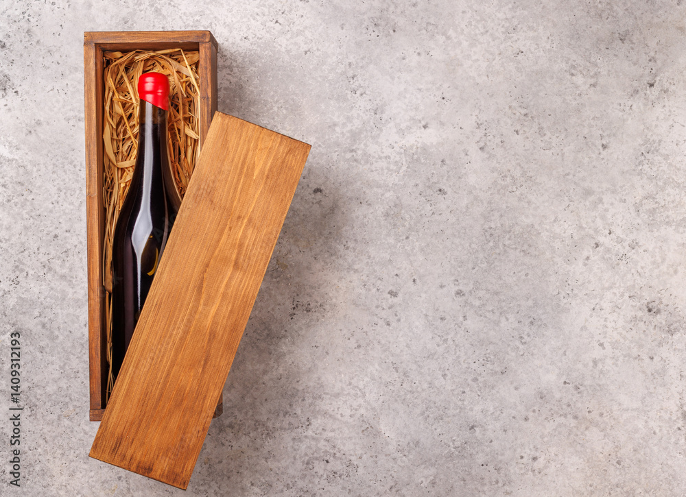 Obraz premium A red wine bottle elegantly placed inside a rustic wooden box