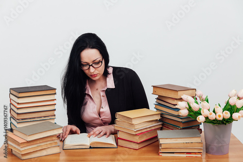 business woman teacher and stacks of educational books on table