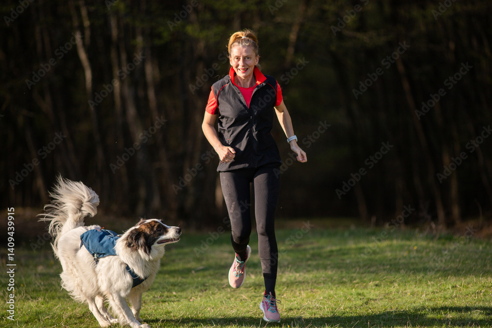 fit happy woman running with her dog outdoors