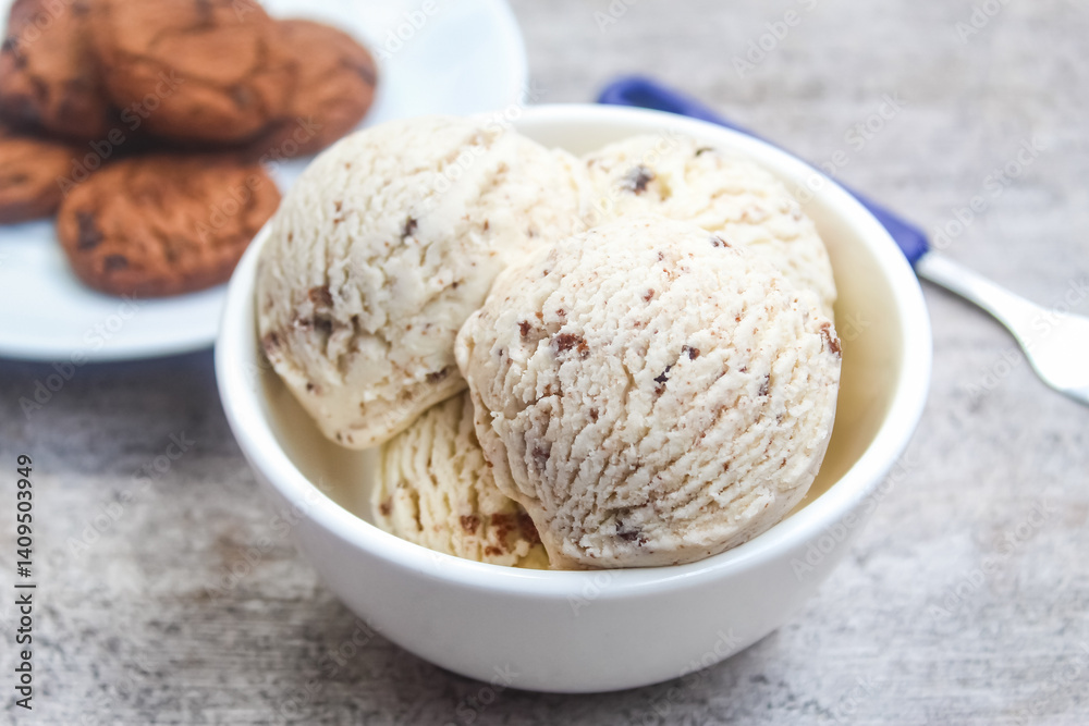 Fototapeta premium a bowl of vanilla scoop ice cream, with chocolate chip cookies