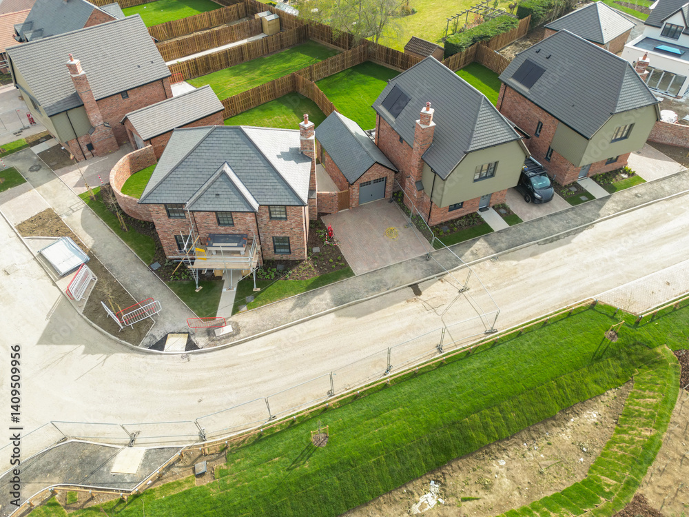 Aerial view of expensive, detached family homes near completion on a British housing site. Notice the newly laid lawns.