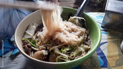 Rice Noodles Beef Soup with Beef Intestine Braised ontop Garlic and Stink Weed decorate Spring onions and Basil Thai herbs. Thai Boat Noodles Style topview
