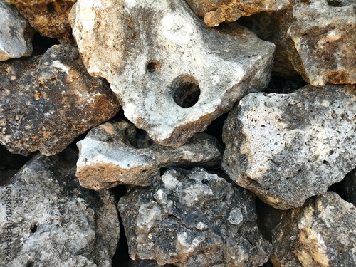 Close-up of a rough stone wall with natural textures and earthy tones. Ideal for backgrounds, construction themes, nature textures, or rustic design elements