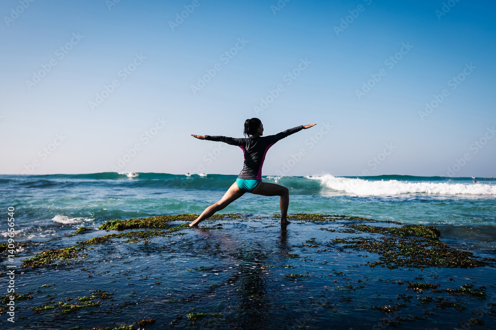 Woman practice yoga at seaside cliff edge facing the coming strong sea waves Woman practice yoga at seaside cliff edge facing the coming strong sea waves
