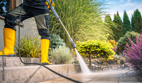 Obraz na płótnie Person Using Pressure Washer for Outdoor Cleaning on Sunny Day w salonie