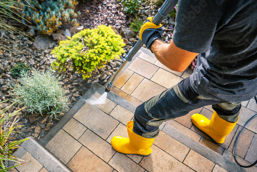 Obraz na płótnie Cleaning Outdoor Steps With a Pressure Washer in Bright Yellow Boots w salonie