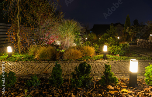 Obraz na płótnie Beautiful Garden Illuminated by Soft Lights at Night w salonie