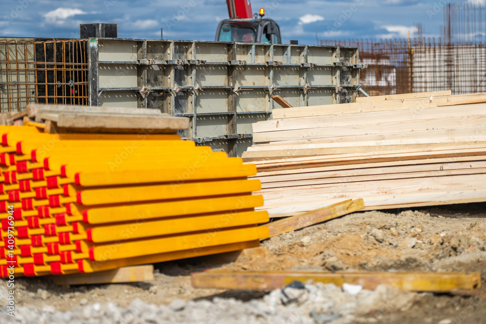 Construction Site With Stacked Lumber and Concrete Forms