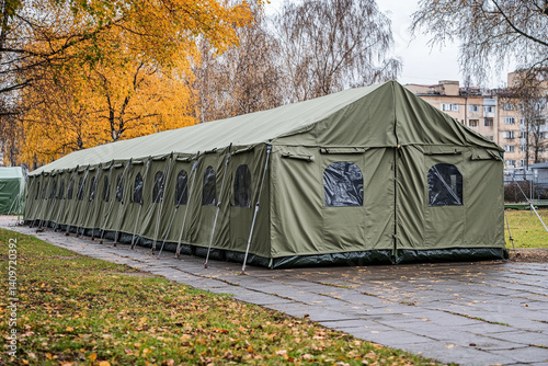 Long army green tent in autumn park setting