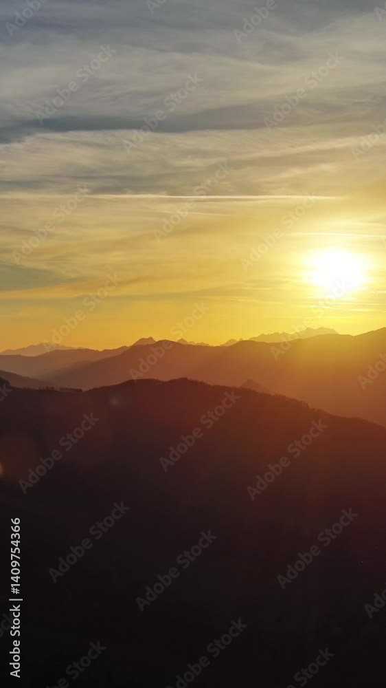 Flying over colorful foliage at sunset in mountains. Vibrant autumn landscape. Vertical video