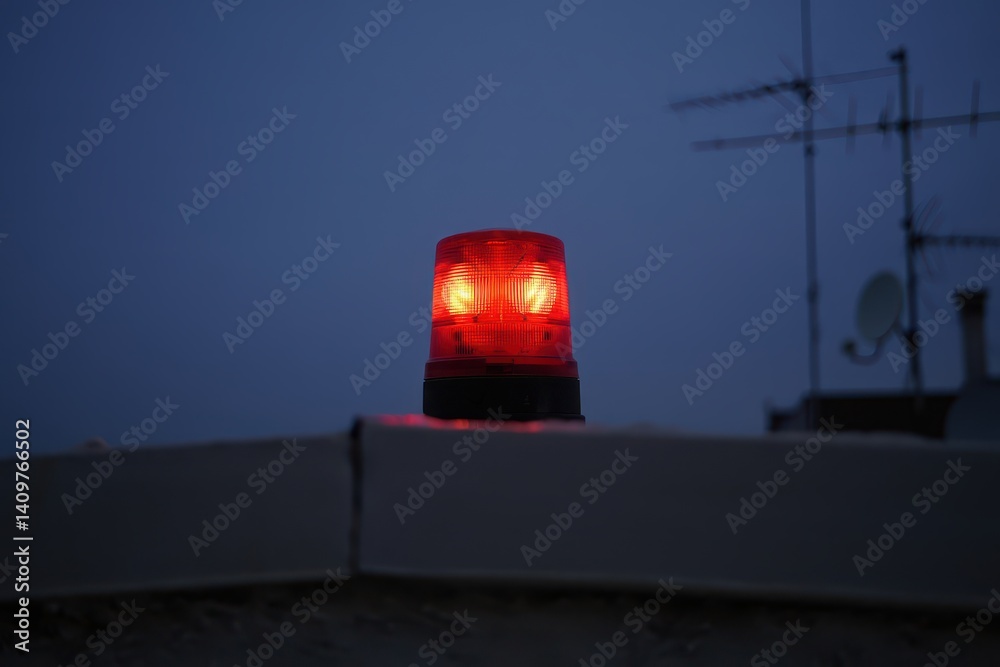 Warning issue notice concept. Flashing red light atop a building against a night sky backdrop. Warning issue notice concept. Flashing red light atop a building against a night sky backdrop.