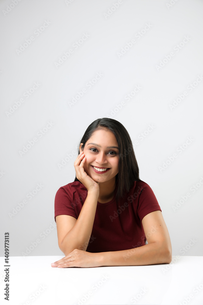 Indian young girl or woman smiling with pam on her face isolated on white background Indian young girl or woman smiling with pam on her face isolated on white background