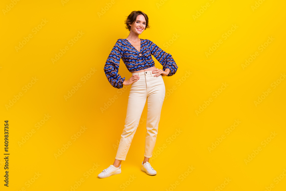 Fototapeta premium Full body length photo of candid girl posing model in retro summer shirt touching waist and white pants isolated on yellow color background